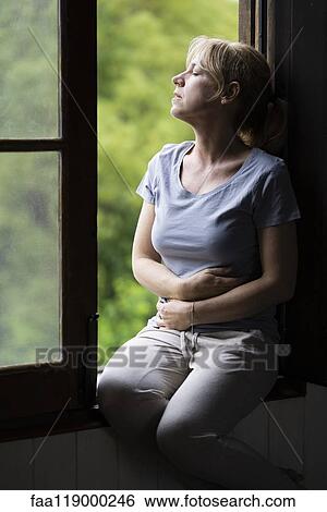 Stock Photograph - Woman sitting on window. Fotosearch