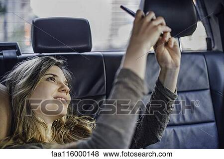 Stock Photo - Woman taking selfie with smartphone. Fotosearch