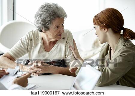 Woman talking with her mother in clinic View Large Photo Image Stock Photo - Woman talking with her mother in clinic. Fotosearch