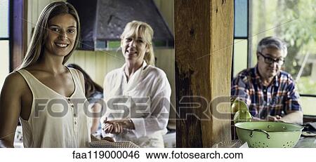 Stock Photograph - Woman with her parents standing in kitchen. Fotosearch