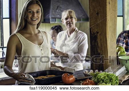 Stock Photography - Woman with her parents standing in kitchen. Fotosearch