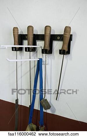 Stock Image - Work tools hanging on wall. Fotosearch
