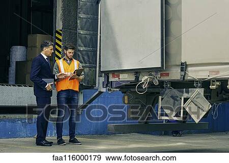 Worker and businessman discussing near lorry View Large Photo Image Stock Photo - Worker and businessman discussing near lorry. Fotosearch