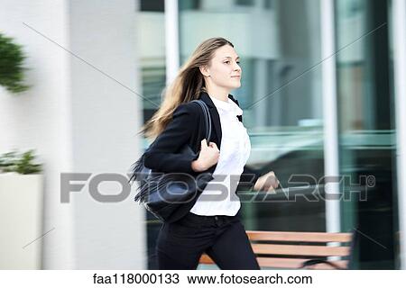 Young businesswoman running on pavement View Large Photo Image Stock Image - Young businesswoman running on pavement. Fotosearch