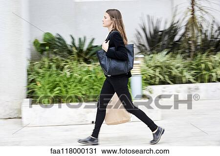 Young businesswoman walking on pavement View Large Photo Image Stock Image - Young businesswoman walking on pavement. Fotosearch