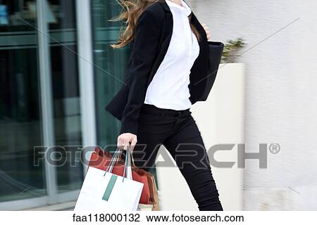 Young businesswoman walking on pavement View Large Photo Image Stock Image - Young businesswoman walking on pavement. Fotosearch
