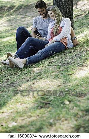 Young couple listening to music on smartphone View Large Photo Image Picture - Young couple listening to music on smartphone. Fotosearch