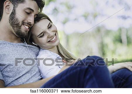Young couple listening to music on smartphone View Large Photo Image Stock Image - Young couple listening to music on smartphone. Fotosearch