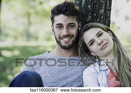 Young couple listening to music on headphones View Large Photo Image Stock Photo - Young couple listening to music on headphones. Fotosearch