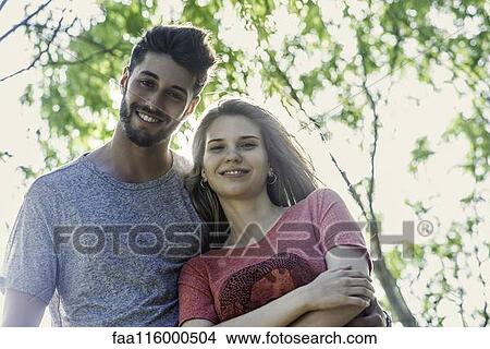 Picture - Young couple standing in park. Fotosearch