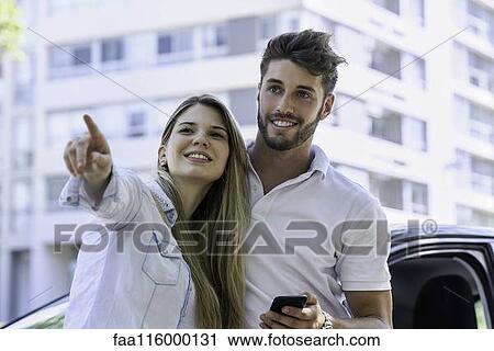 Stock Image - Young couple standing outdoors. Fotosearch
