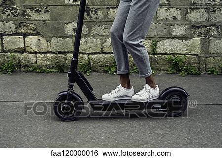 Stock Photograph - Young man riding push scooter. Fotosearch