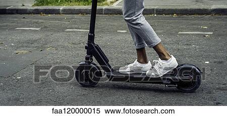 Stock Photography - Young man riding push scooter. Fotosearch