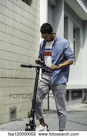 Stock Image - Young man using smart phone. Fotosearch