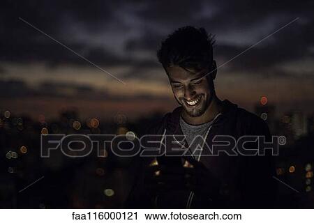 Stock Image - Young man using smartphone. Fotosearch