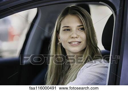 Young woman in car View Large Photo Image Stock Image - Young woman in car. Fotosearch