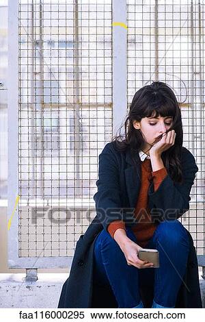 Young woman sitting near fence View Large Photo Image Stock Photography - Young woman sitting near fence. Fotosearch