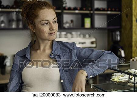 Young woman standing in bakery View Large Photo Image Stock Image - Young woman standing in bakery. Fotosearch