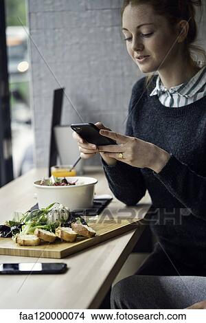 Young woman taking picture in restaurant View Large Photo Image Picture - Young woman taking picture in restaurant. Fotosearch