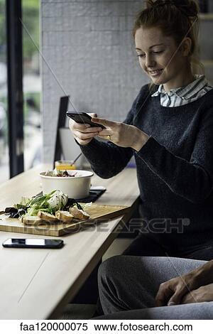 Young woman taking picture in restaurant View Large Photo Image Stock Photography - Young woman taking picture in restaurant. Fotosearch