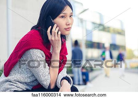 Young woman talking on smartphone View Large Photo Image Picture - Young woman talking on smartphone. Fotosearch