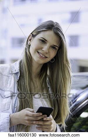 Stock Image - Young woman using smartphone. Fotosearch