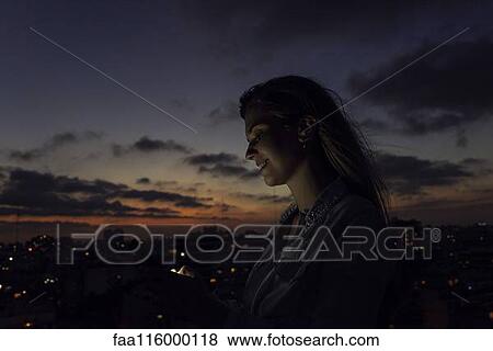 Stock Photo - Young woman using smartphone. Fotosearch