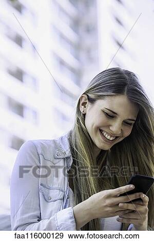 Young woman using smartphone View Large Photo Image Stock Photo - Young woman using smartphone. Fotosearch