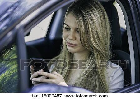 Stock Photo - Young woman using smartphone. Fotosearch