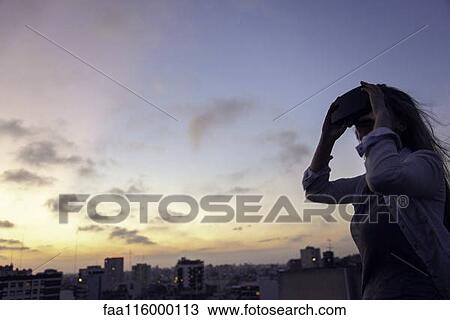 Stock Image - Young woman with virtual reality headset. Fotosearch