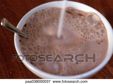 Chocolate milk in bowl, with spoon, liquid being poured into bowl, blurred View Large Photo Image Stock Photo - Chocolate milk in bowl, with spoon, liquid being poured into bowl, blurred. Fotosearch