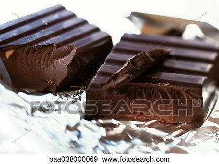 Stock Photo - Chunks of dark chocolate on aluminum foil. Fotosearch