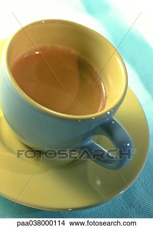 Cup and saucer, yellow and blue, high angle view, close-up, tilt. View Large Photo Image Picture - Cup and saucer, yellow and blue, high angle view, close-up, tilt.. Fotosearch