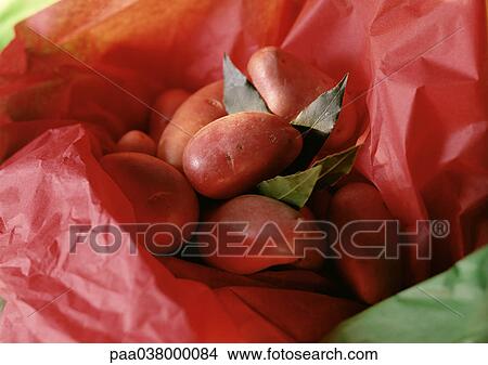 Picture - New potatoes with bay leaves in tissue paper. Fotosearch