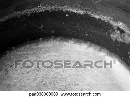 Stock Photo - Saucepan with milk froth, close-up. Fotosearch