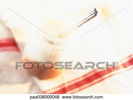 Stock Photo - Spoon in yogurt, close-up, blurred. Fotosearch