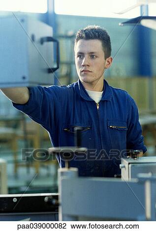 Man in coveralls in workshop View Large Photo Image Stock Image - Man in coveralls in workshop. Fotosearch