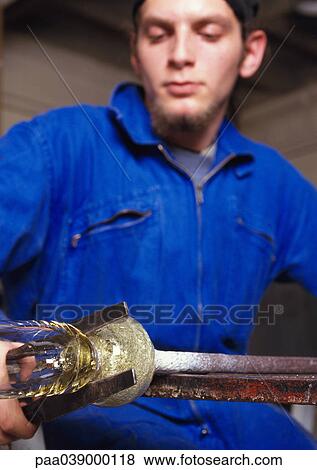 Stock Photo - Man in coveralls, working glass. Fotosearch