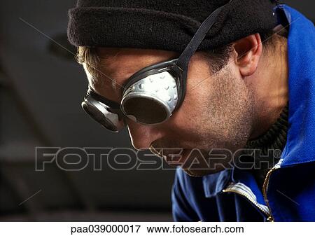 Stock Photo - Man wearing protective glasses, close-up. Fotosearch