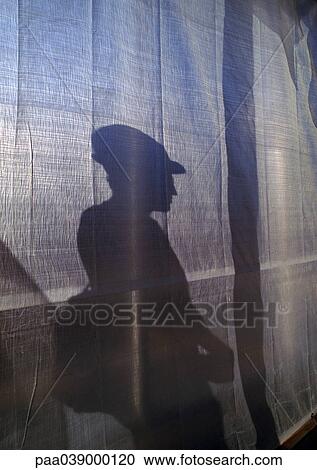Stock Image - Shadow of man wearing hard hat. Fotosearch