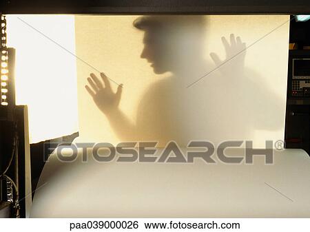 Stock Photograph - Silhouette of man behind sheet of paper. Fotosearch