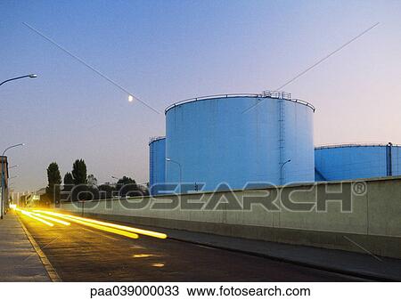 Storage tanks next to road with car light trails View Large Photo Image Stock Image - Storage tanks next to road with car light trails. Fotosearch