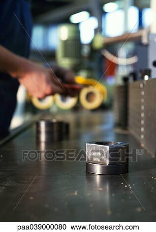 Stock Image - Workbench, hands in background. Fotosearch