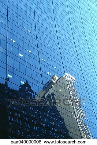 Stock Photograph - Buildings reflected in window panes of skyscraper. Fotosearch