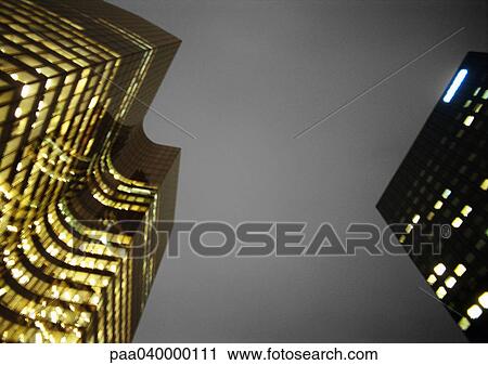 Stock Image - Skyscrapers at night, low angle view. Fotosearch