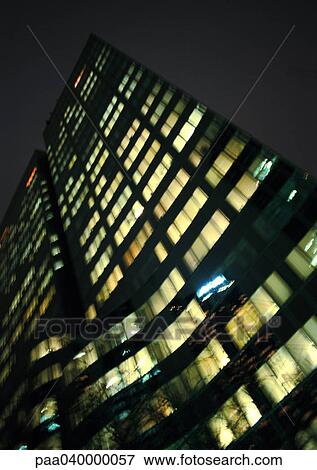 Stock Photo - Skyscraper's facade at night, low angle view. Fotosearch