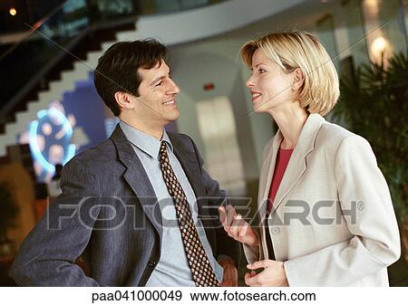 Businessman and businesswoman standing face to face, smiling View Large Photo Image Stock Photo - Businessman and businesswoman standing face to face, smiling. Fotosearch