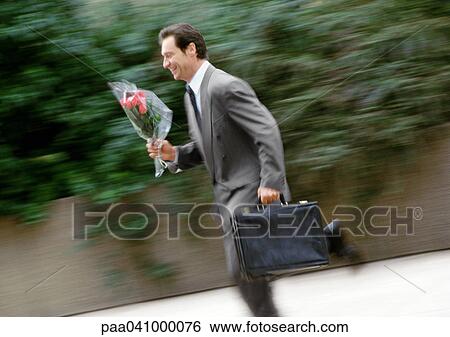 Businessman holding briefcase and bouquet of flowers, running, blurred View Large Photo Image Stock Photograph - Businessman holding briefcase and bouquet of flowers, running, blurred. Fotosearch