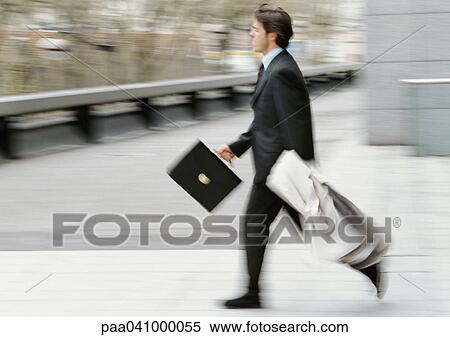 Businessman holding briefcase and overcoat, running, blurred View Large Photo Image Stock Photography - Businessman holding briefcase and overcoat, running, blurred. Fotosearch