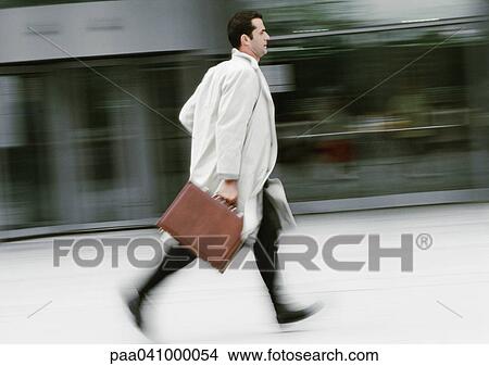 Businessman holding briefcase, running, blurred View Large Photo Image Picture - Businessman holding briefcase, running, blurred. Fotosearch